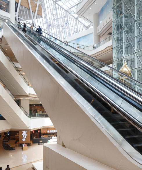 How does the handrail synchronization monitoring system ensure the safety of passengers on heavy-duty escalators?